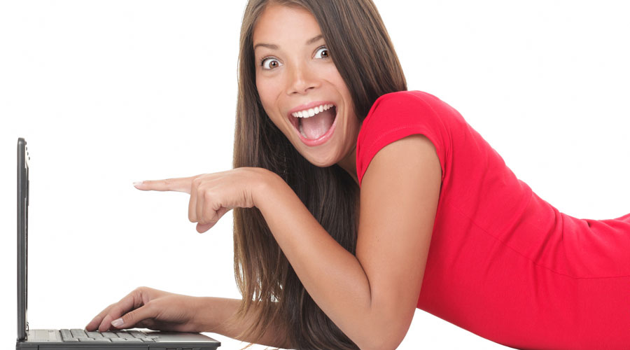 Young woman in a red dress pointing at her laptop